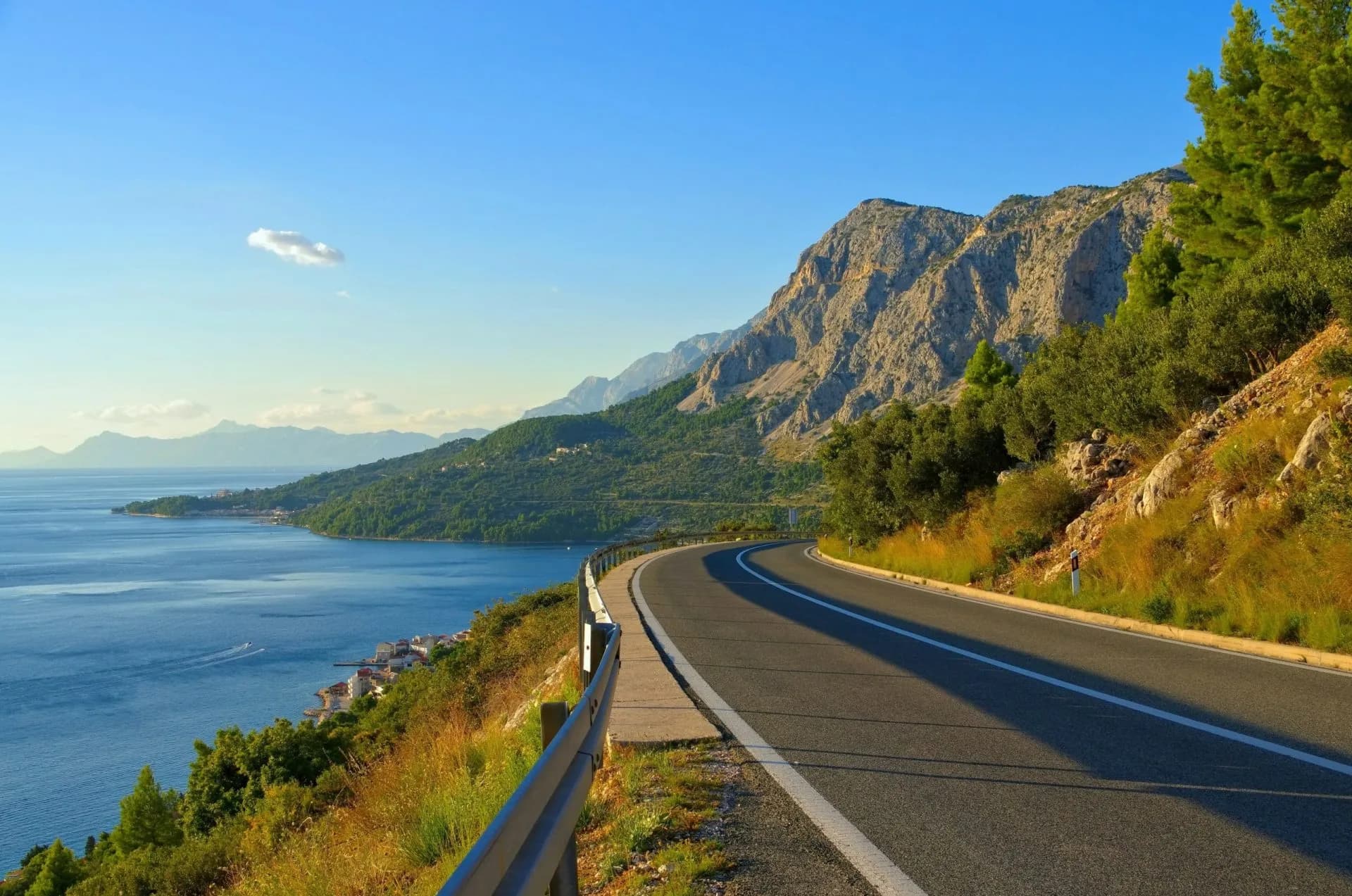 Winding coastal highway next to steep mountains and the blue Adriatic Sea