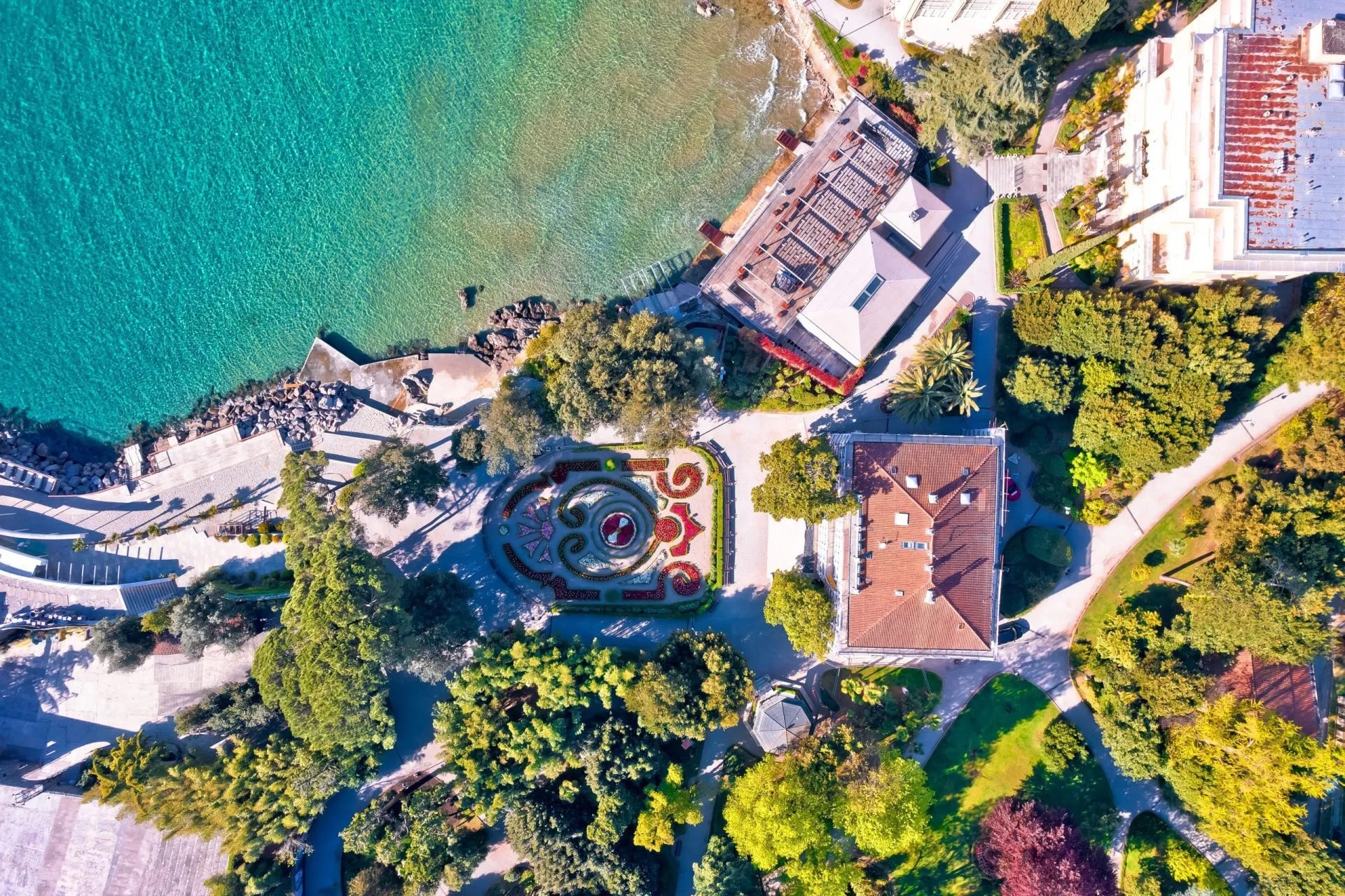 Aerial view of Lungomare coastal promenade in Lovran with turquoise sea and formal garden.