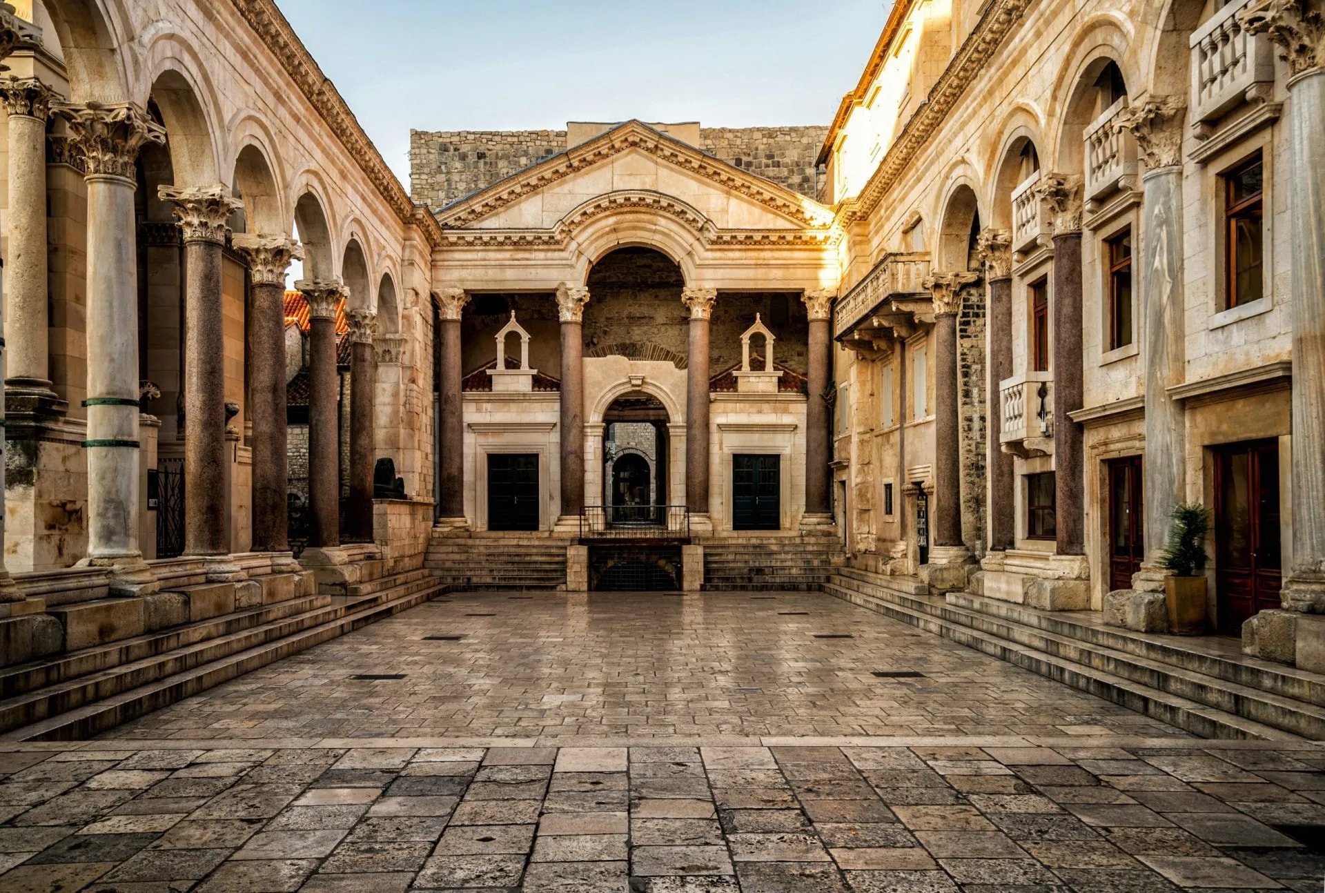 Diocletian Palace courtyard with stone pavement, colonnades, and central entrance in Split.
