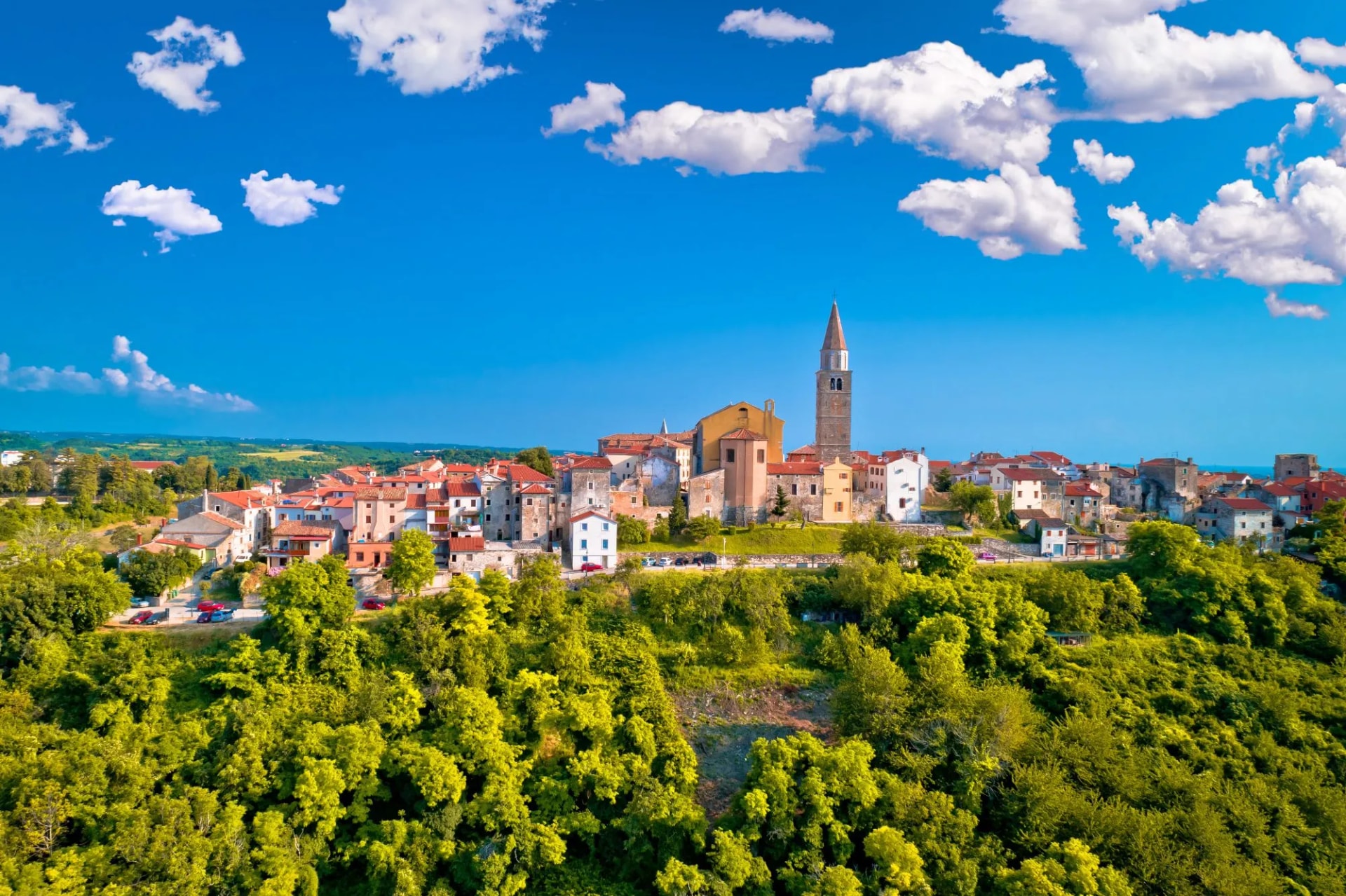Old stone town of Buje on green hill aerial view